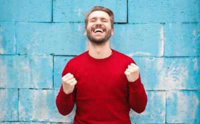 man-in-red-shirt-pumping-arms-due-to-success